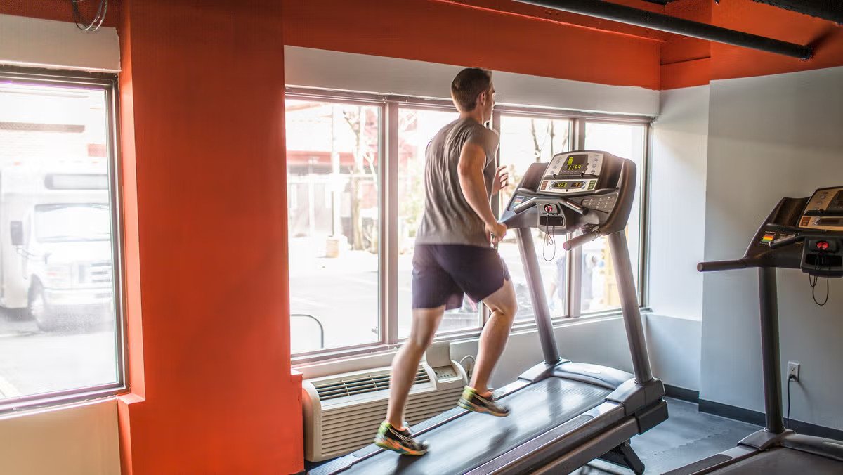 A person running uphill on a treadmill, demonstrating a high-intensity cardio workout.