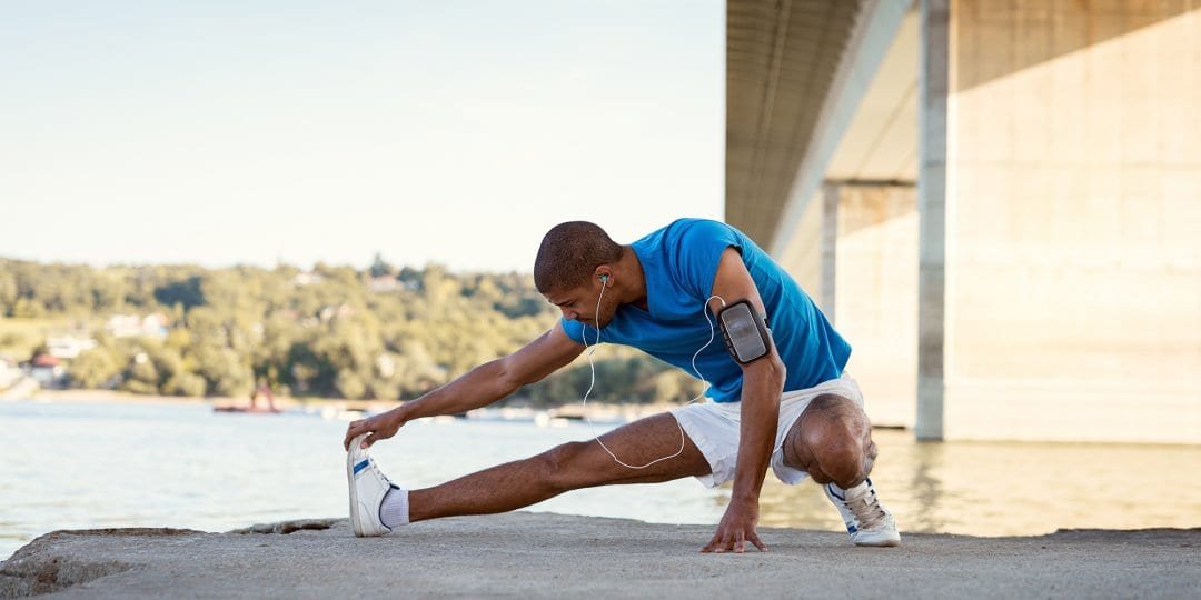 An athlete performing dynamic stretches before a workout, emphasizing the importance of warming up.